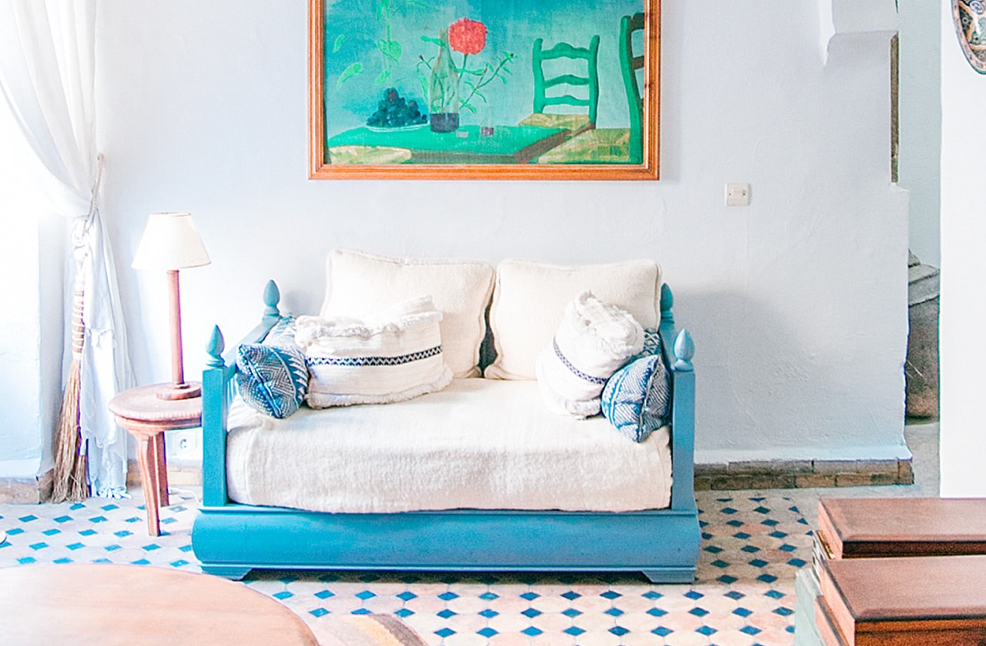 A morrocan style living room with soft linens and bright blue accents.